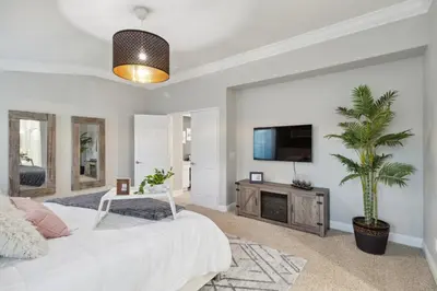 a living room with a white bed and a tv at 5BR 3BA Home - King Beds - Fast Wifi home in Victorville