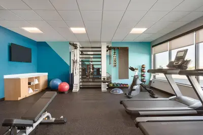 a gym with blue walls and tread machines at avid hotel Victorville Hesperia by IHG in Victorville