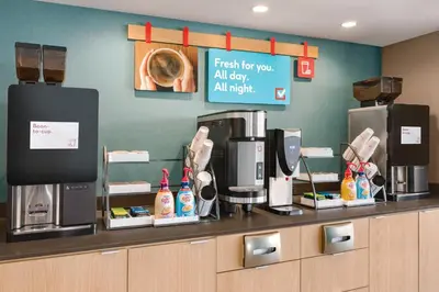 a coffee shop with a counter with a coffee machine at avid hotel Victorville Hesperia by IHG in Victorville