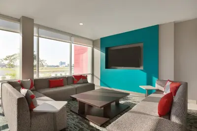 a living room with a couch and a tv on a wall at avid hotel Victorville Hesperia by IHG in Victorville