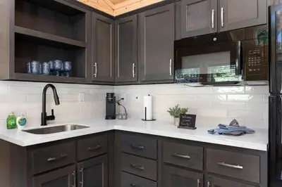 a kitchen with brown cabinets and a sink at Brand New Cabin in Kernville