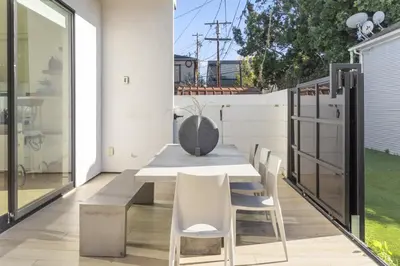 a dining room with a table and chairs on a balcony at The Penmar Retreat - Luxurious resort-style oasis in Los Angeles
