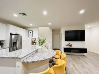 a kitchen with a counter and yellow chairs in a room at Up to 25% OFF / New Built for Ideal Extended Stay in Fontana