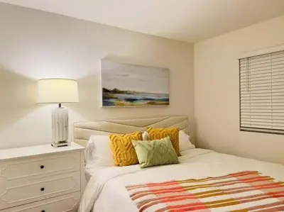a bedroom with a bed with yellow pillows and a lamp at Up to 25% OFF / New Built for Ideal Extended Stay in Fontana