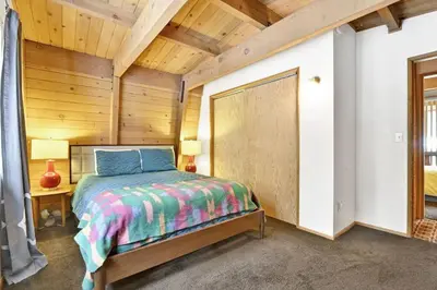 a bedroom with a bed and a wooden ceiling at Quail's Call Big Bear~ Walk to Lake & Ski Resort in Big Bear Lake