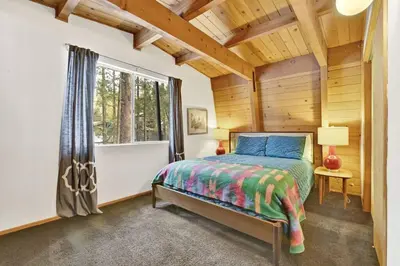 a bedroom with a bed in a room with a window at Quail's Call Big Bear~ Walk to Lake & Ski Resort in Big Bear Lake