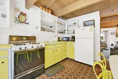 a kitchen with yellow cabinets and a white refrigerator at Quail's Call Big Bear~ Walk to Lake & Ski Resort in Big Bear Lake
