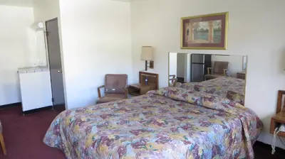 a hotel room with a bed and two chairs at Eagle Rock Motel in Los Angeles
