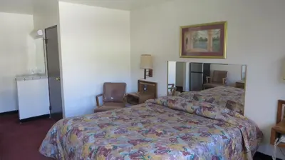 a hotel room with a bed and chairs in it at Eagle Rock Motel in Los Angeles