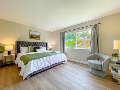 a bedroom with a bed and a chair and a window at Sweet 2 bd for monthly stay! 20 mi to Disney in Diamond Bar