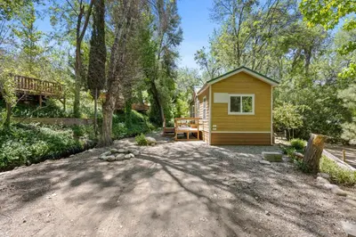 a small cabin in the woods with a patio at Brand new Cabins in Kernville