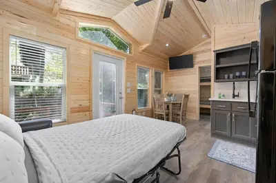 a bedroom with a bed in a room with wooden walls at Brand new Cabins in Kernville