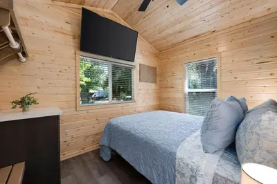 a bedroom with a bed and a flat screen tv at Brandnew cabin in Kernville
