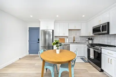 a kitchen with a table and a refrigerator at Sunset Beach Retreat next to Water Tower and Ocean in Sunset Beach