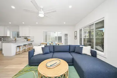 a living room with a blue couch and a table at Sunset Beach Retreat next to Water Tower and Ocean in Sunset Beach