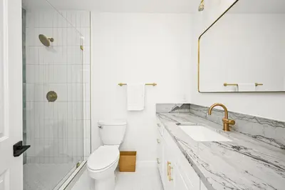 a white bathroom with a sink and a toilet at Sunset Beach Retreat next to Water Tower and Ocean in Sunset Beach