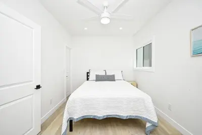a white bedroom with a bed and a ceiling at Sunset Beach Retreat next to Water Tower and Ocean in Sunset Beach