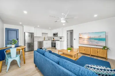 a living room with a blue couch and a kitchen at 130 Anderson St A in Sunset Beach