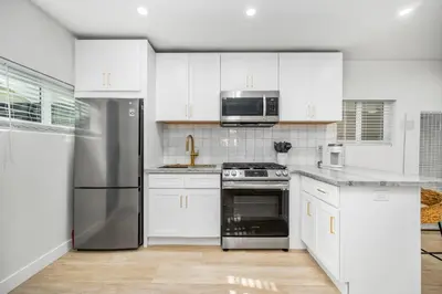 a kitchen with white cabinets and a stainless steel refrigerator at 130 Anderson St B in Sunset Beach