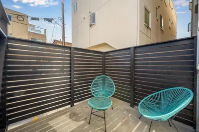 two blue chairs on a balcony with a fence at 130 Anderson St B in Sunset Beach