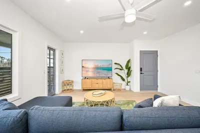 a living room with a blue couch and a table at Brand New Home by the Beach & Historic Sunset Water Tower in Sunset Beach