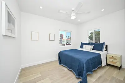 a white bedroom with a bed and a ceiling fan at Brand New Home by the Beach & Historic Sunset Water Tower in Sunset Beach
