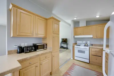 a kitchen with wooden cabinets and a white stove top oven at Oak View Home - Close to Beaches and Trails! in Oak View