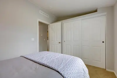 a bedroom with a bed and white walls and doors at Oak View Home - Close to Beaches and Trails! in Oak View