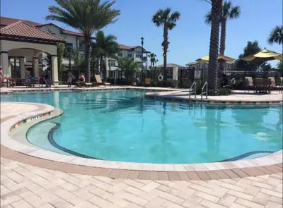 a large swimming pool at a resort with palm trees at Partial Ocean View Steps to the Pier in Los Angeles