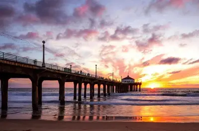 a pier on the beach with a sunset in the background at Partial Ocean View Steps to the Pier in Los Angeles