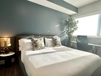 a bedroom with a white bed with a blue wall at Hollywood Sign View 2 Bed 2 Bath Premium Corner in Los Angeles