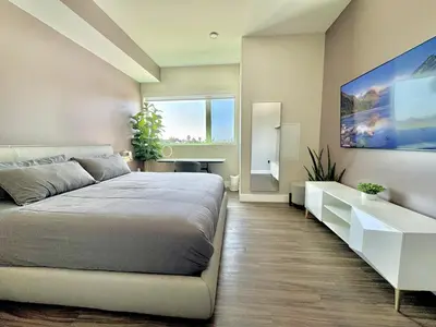 a bedroom with a bed and a large painting on the wall at Large Hollywood Corner 2 Bedroom with Private Balcony in Los Angeles