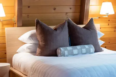 a bedroom with a bed with pillows and two lamps at Pet & Kid Friendly Cozy Cabin, BBQ, Firepit, Outdoor Dining, Forest Views in Lake Arrowhead