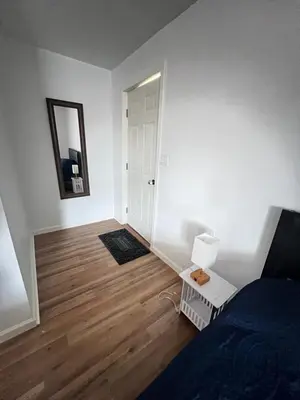 a living room with a bed and a mirror at LittleBettysCrashPad in Torrance