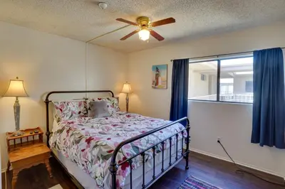 a bedroom with a bed and a ceiling fan at 1 Mi to the Ocean Long Beach Condo with Pool Access in Long Beach