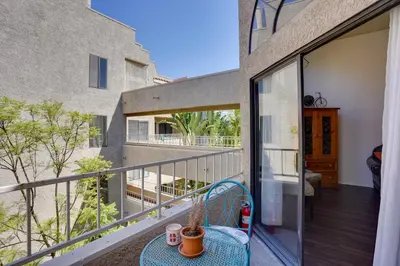 a balcony with a table and chairs on a building at 1 Mi to the Ocean Long Beach Condo with Pool Access in Long Beach