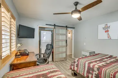 a bedroom with a bed and a desk and a tv at Cozy Cabin with Deck - 2 Mi to Bear Mountain Resort! in Big Bear Lake