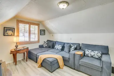 a living room with a blue couch and a chair at Cozy Cabin with Deck - 2 Mi to Bear Mountain Resort! in Big Bear Lake