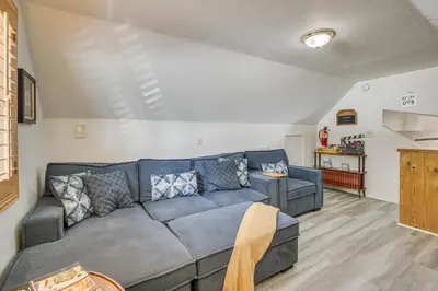 a living room with a blue couch in a room at Cozy Cabin with Deck - 2 Mi to Bear Mountain Resort! in Big Bear Lake
