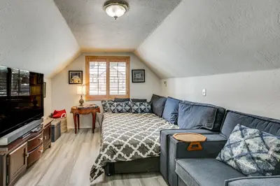 a living room with a blue couch and a tv at Cozy Cabin with Deck - 2 Mi to Bear Mountain Resort! in Big Bear Lake
