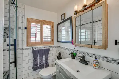 a bathroom with a sink and a toilet and a mirror at Cozy Cabin with Deck - 2 Mi to Bear Mountain Resort! in Big Bear Lake