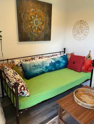 a couch with pillows on it in a living room at Petite Guesthouse with Kitchenette and Private Bathroom in Lake Isabella
