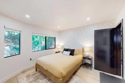 a bedroom with a large bed and two windows at The Snow White in Lake Arrowhead