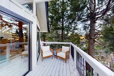a balcony with two chairs and a tree on it at The Snow White in Lake Arrowhead