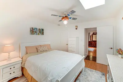 a white bedroom with a bed and a ceiling fan at Family-Friendly Loma Linda Retreat Walk to LLU in Loma Linda