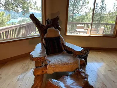 a wooden chair with snow on it in a living room at Outrageous Lake View Villa pets ok in Lake Arrowhead