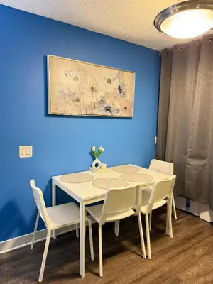 a table and chairs in a room with a blue wall at Hollywood Blvd Studio FREE DESIGNATED PARKING & WIFI in Los Angeles