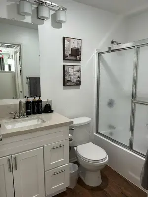 a white bathroom with a toilet and a shower at Hollywood Blvd Studio FREE DESIGNATED PARKING & WIFI in Los Angeles