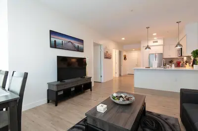 a living room with a couch and a table and a kitchen at Comfy Apt with pool & hot tub in downtown LA' in Los Angeles
