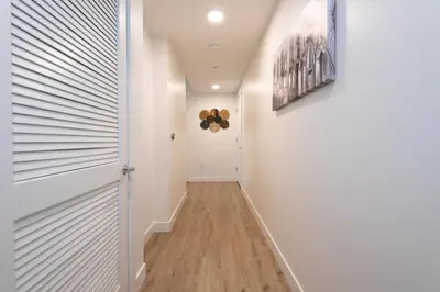 a hallway with white walls and a white door at Comfy Apt with pool & hot tub in downtown LA' in Los Angeles